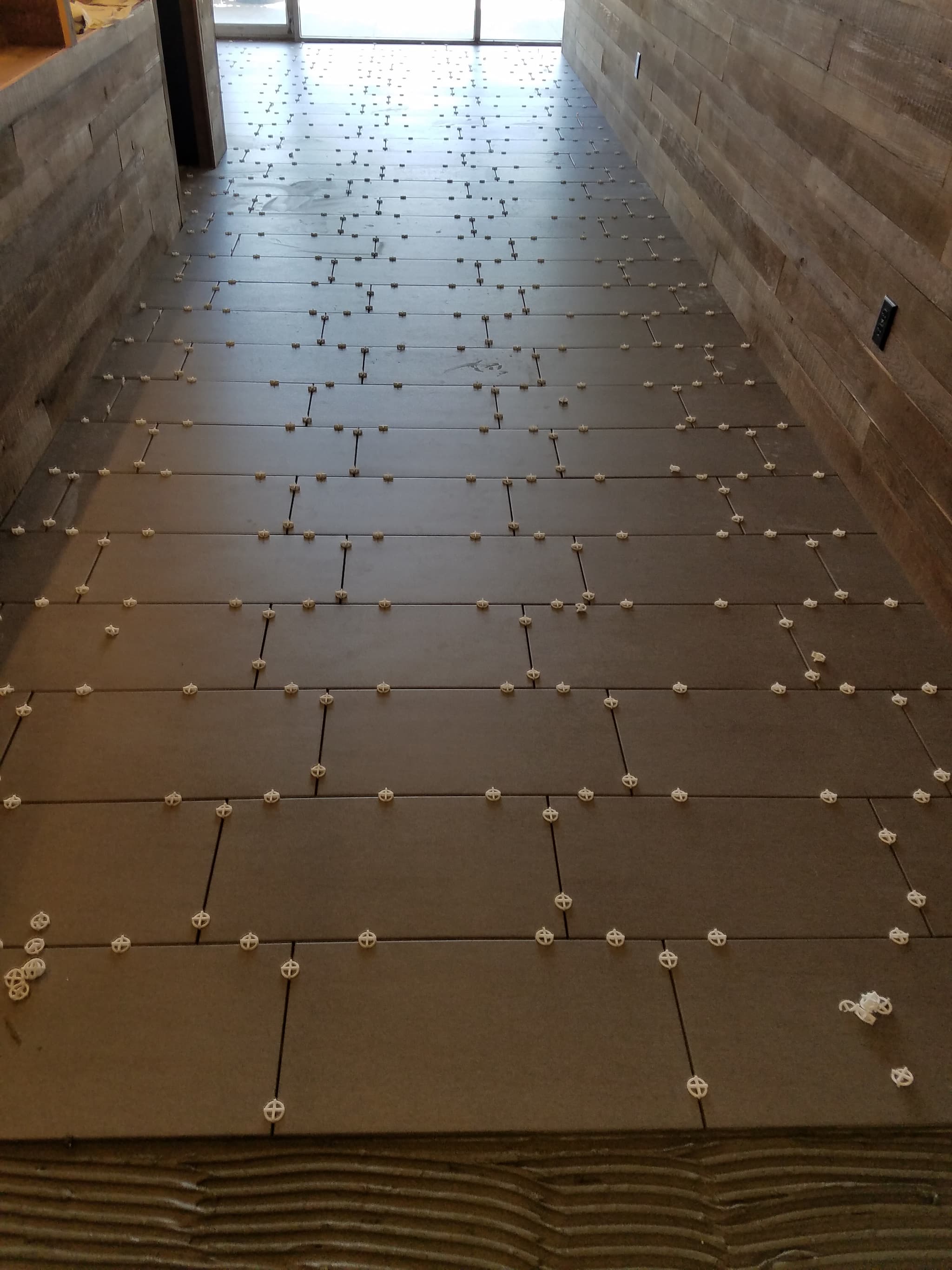 Large format porcelain floor tile installation with spacers