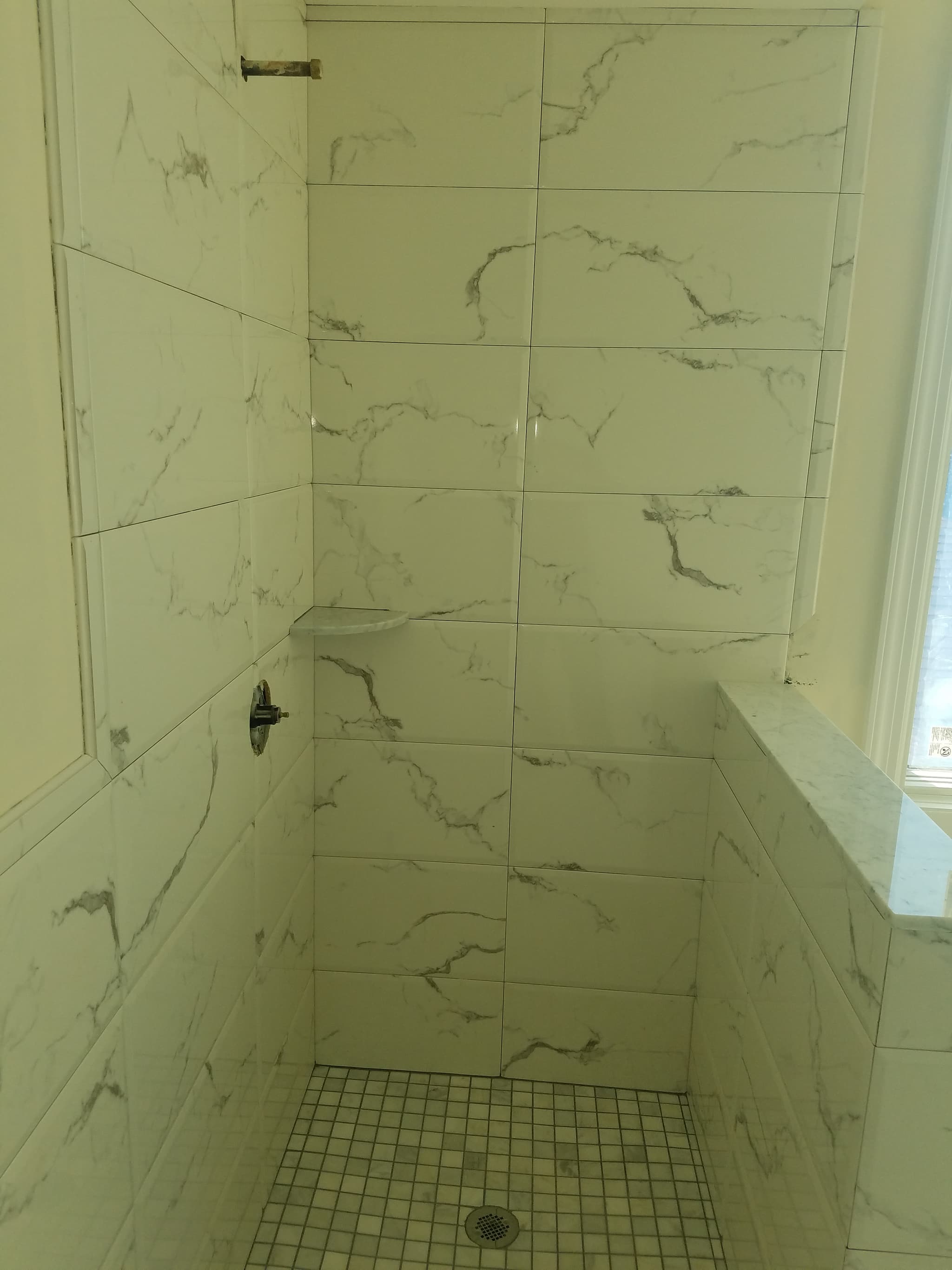 Marble-look shower wall tile installation