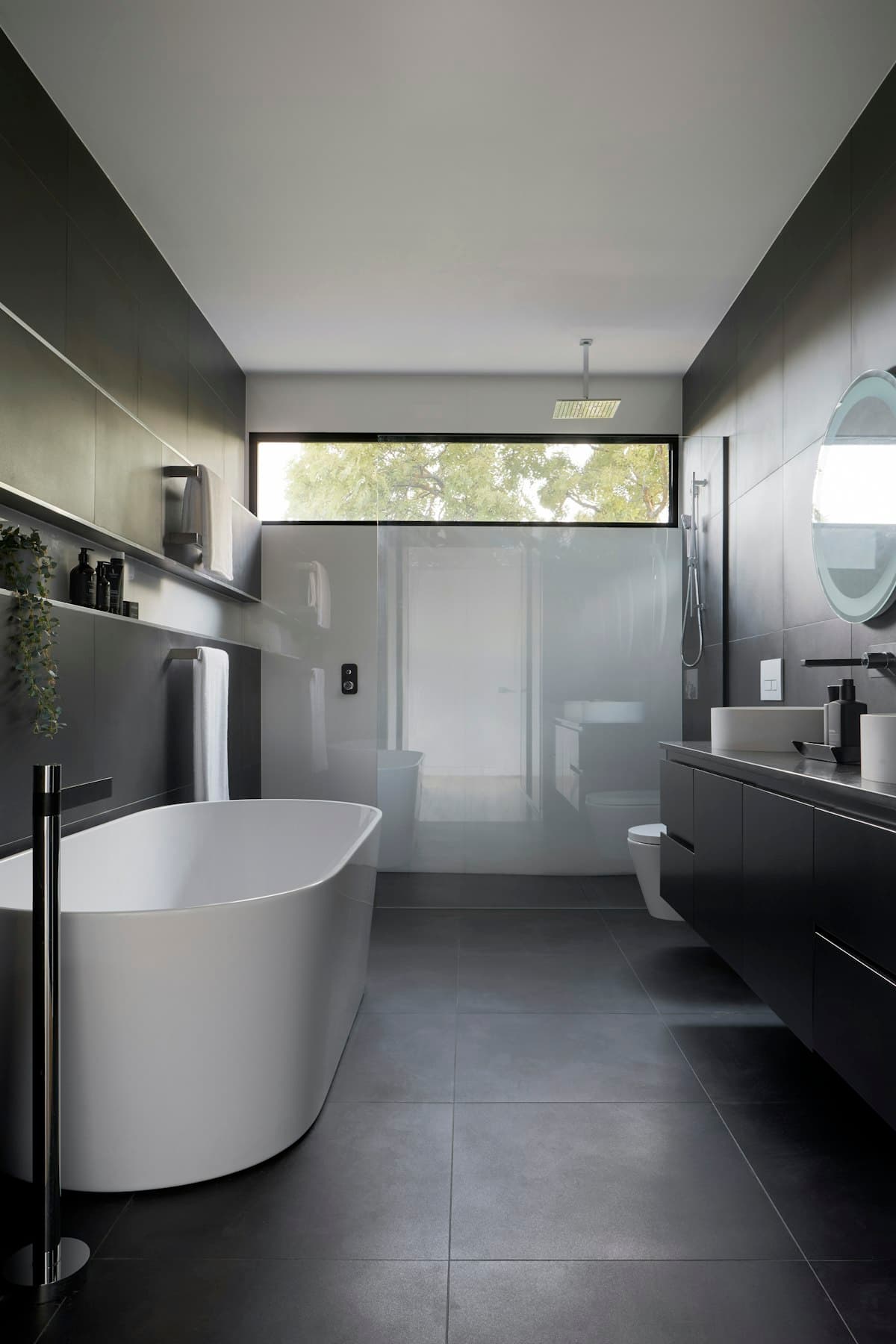 Luxury bathroom featuring large format porcelain tiles on walls and floor with freestanding tub